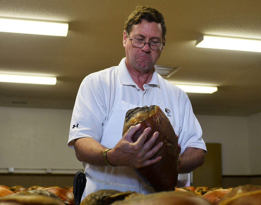Ham judge Andrew Clarke inspects the "eye appeal" of a ham